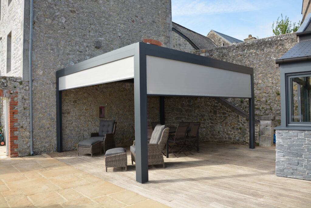 Vue d'une pergola bioclimatique avec stores électriques marque Store Marquise